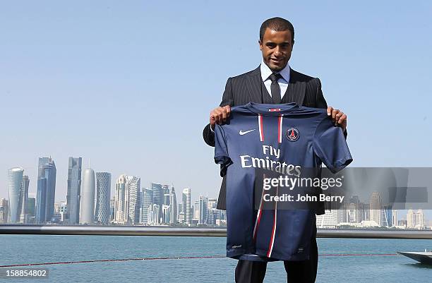 New signing Lucas Moura of PSG poses with a shirt as he is officially unveiled as a player of Paris Saint-Germain during a press conference and...
