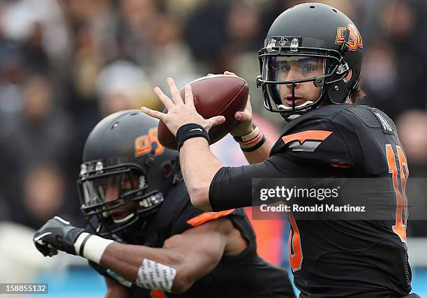 Clint Chelf of the Oklahoma State Cowboys passes against the Purdue Boilermakers during the Heart of Dallas Bowl at Cotton Bowl on January 1, 2013 in...