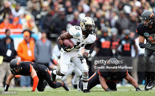 Akeem Hunt of the Purdue Boilermakers runs the ball against the Oklahoma State Cowboys during the Heart of Dallas Bowl at Cotton Bowl on January 1,...