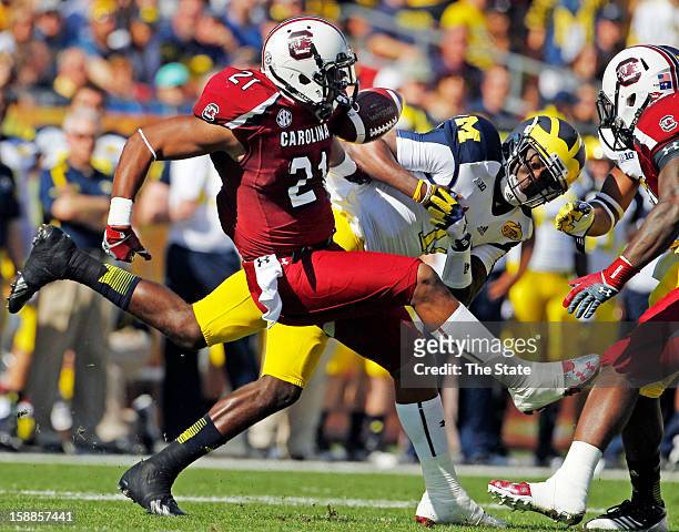 South Carolina linebacker DeVonte Holloman forces a fumble by Michigan quarterback Devin Gardner in the first quarter in the Outback Bowl at Raymond...