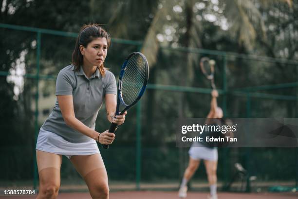 2 chinese female tennis players playing in tennis court - doubles stock pictures, royalty-free photos & images