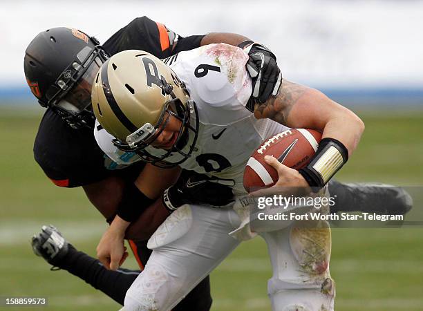 Oklahoma State Cowboys cornerback Brodrick Brown takes down Purdue Boilermakers quarterback Robert Marve during the Heart of Dallas Bowl on Tuesday,...