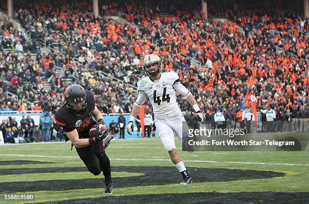 Oklahoma State Cowboys wide receiver Blake Webb makes a 37-yard touchdown reception against Purdue Boilermakers safety Landon Feichter during the...