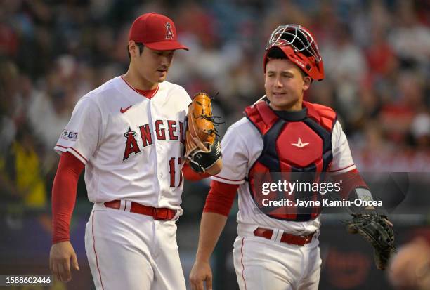 Shohei Ohtani of the Los Angeles Angels talks with Matt Thaiss after the fourth inning against the San Francisco Giants at Angel Stadium of Anaheim...