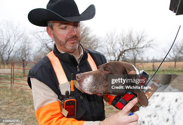 Ted Gartner checks the GPS collar on Vegas, one of his hunting dogs, December 19 in Edwards County, Kansas.