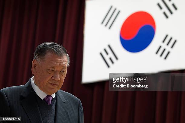 Chung Mong Koo, chairman of Hyundai Motor Co. And Kia Motors Corp., walks in front of South Korea's national flag during a new year company meeting...