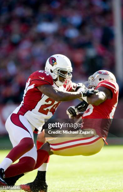 Vernon Davis of the San Francisco 49ers gets tackled by Adrian Wilson of the Arizona Cardinals after making a reception during the game at...