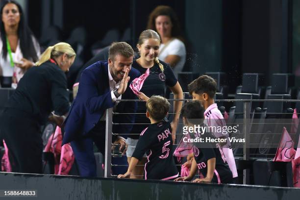 Co-owner David Beckham of Inter Miami CF gives the sons of Lionel Messi high fives following a severe weather delay prior to the Leagues Cup 2023...