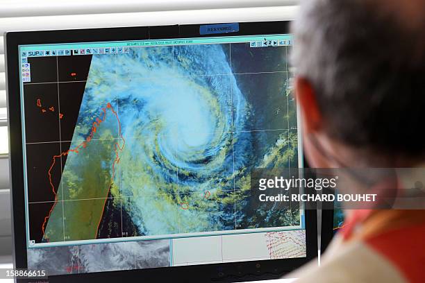 Man looks at a weather map, on January 2, 2013 at Meteo France local headquarters in Saint-Denis de la Reunion, a French island located in the Indian...