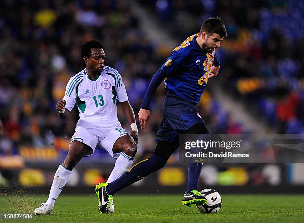 Gerard Pique of Catalonia duels for the ball with Emenike Emmanuel of Nigeria during a friendly match between Catalonia and Nigeria at Cornella-El...