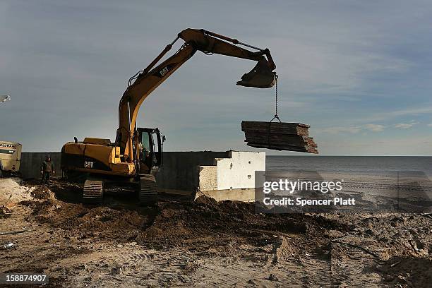 Construction workers build a new sea wall along the beach in the Belle Harbor neighborhood in the Rockaways on January 2, 2013 in the Queens borough...