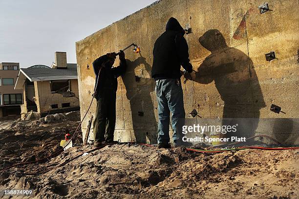 Men help to construct a new sea wall along the beach in the Belle Harbor neighborhood in the Rockaways on January 2, 2013 in the Queens borough of...