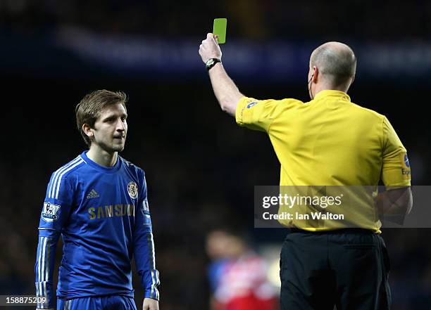 Marko Marin of Chelsea is shown a yellow card by referee Lee Mason after a strong tackle on Stephane Mbia of Queens Park Rangers during the Barclays...