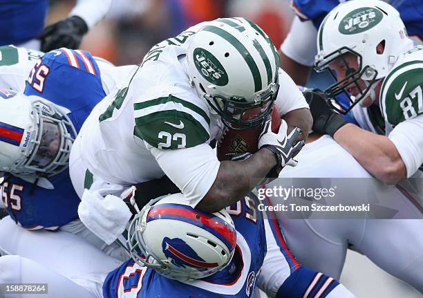 Shonn Greene of the New York Jets tries to pound his way past Nick Barnett of the Buffalo Bills and Kelvin Sheppard as Konrad Reuland blocks for him...