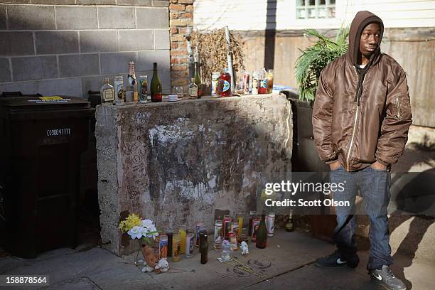 Visitor views the small memorial which marks the spot in an alley where 20-year-old Octavius Dontrell Lamb was shot yesterday and killed, on January...