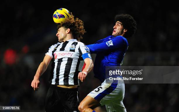 Everton player Marouane Fellani is challenged by Fabricio Coloccini during the Barclays Premier League match between Newcastle United and Everton at...