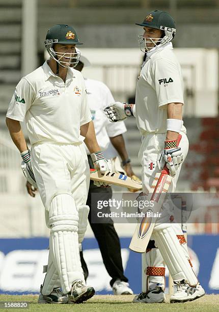 Matthew Hayden of Australia celebrates his century with team mate Adam Gilchrist during day two of the Second Test match between Pakistan and...