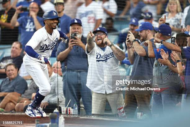 Mookie Betts of the Los Angeles Dodgers celebrates with fans after hitting a solo home run against the Oakland Athletics during the second inning of...