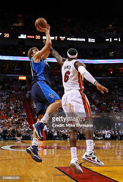 Dirk Nowitzki of the Dallas Mavericks shoots over LeBron James of the Miami Heat during a game at American Airlines Arena on January 2, 2013 in...