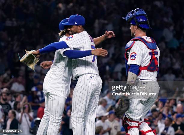 Christopher Morel of the Chicago Cubs hugs Jose Cuas of the Chicago Cubs while Yan Gomes of the Chicago Cubs looks on following their team win over...