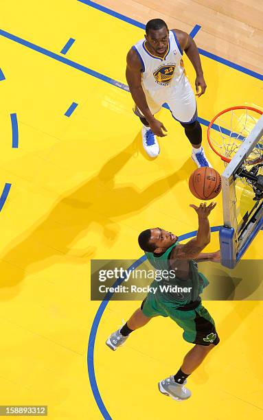 Kris Joseph of the Boston Celtics lays the ball up against Charles Jenkins of the Golden State Warriors on December 29, 2012 at Oracle Arena in...