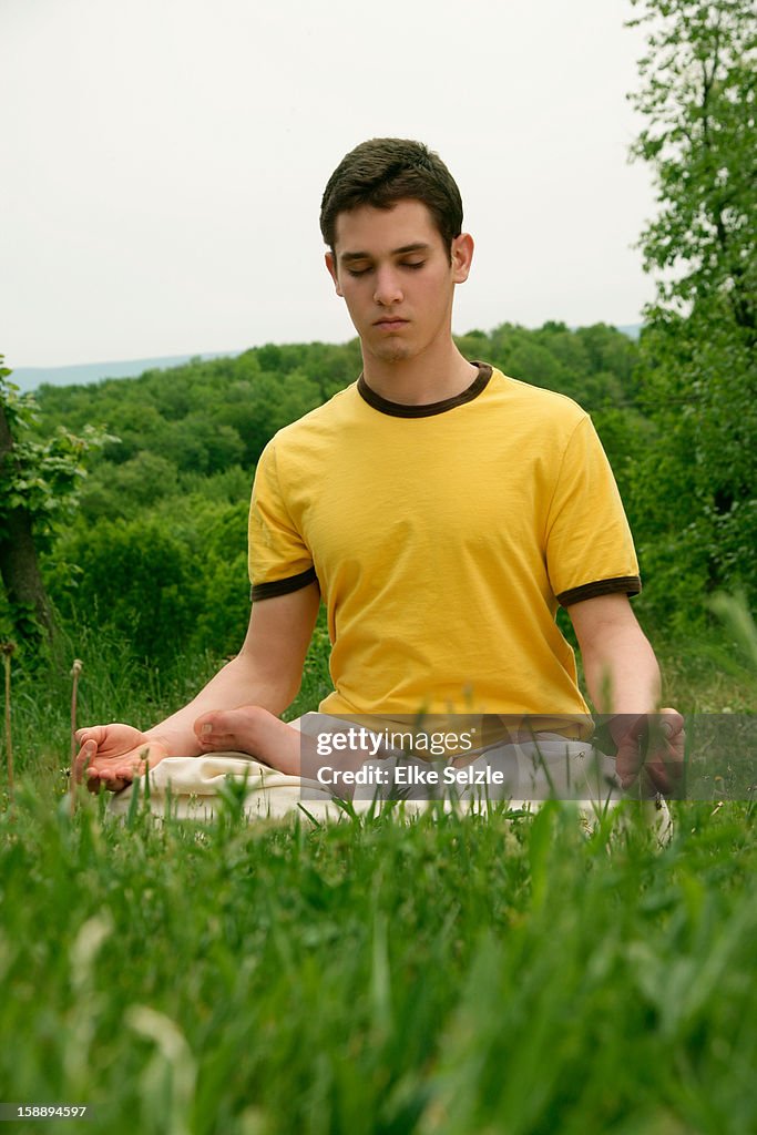 A young man meditating in nature meditating