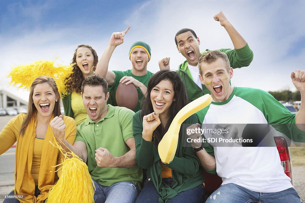 Group of crazy fans tailgating at football game near stadium