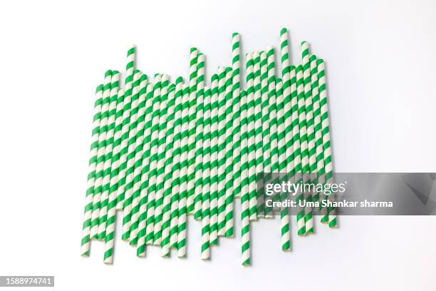 green striped paper straw on white background - belgium india stock pictures, royalty-free photos & images