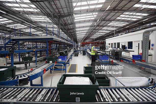 Worker handles an item in the giant semi-automated distribution centre where the company's partners process the online orders for the John Lewis...