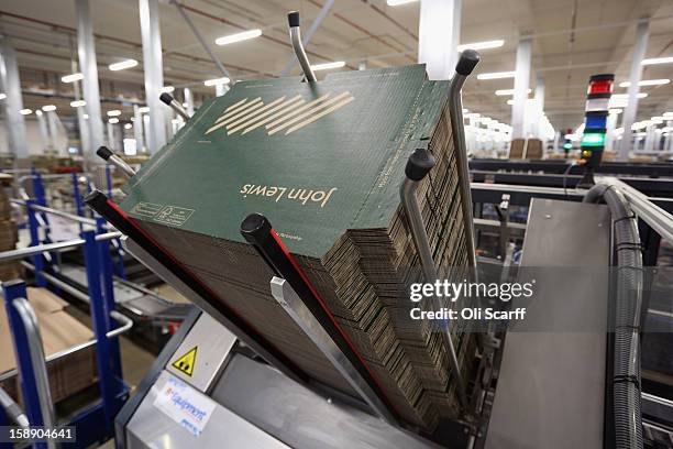 Unfolded lids of boxes are stacked in a hopper of an automated packing machine in the distribution centre where the company's partners process the...