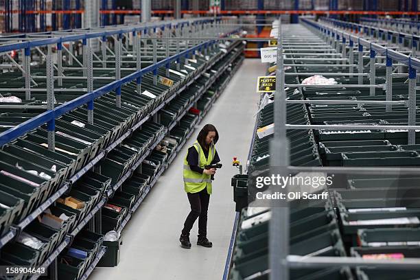 Worker scans an item in the giant semi-automated distribution centre where the company's partners process the online orders for the John Lewis...