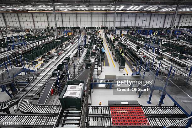 Workers move items for an assembly line in the giant semi-automated distribution centre where the company's partners process the online orders for...