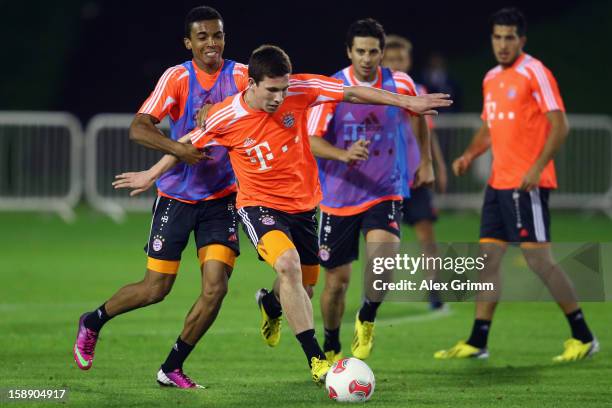 Pierre-Emile Hojbjerg is challenged by Luiz Gustavo during a Bayern Muenchen training session at the ASPIRE Academy for Sports Excellence on January...