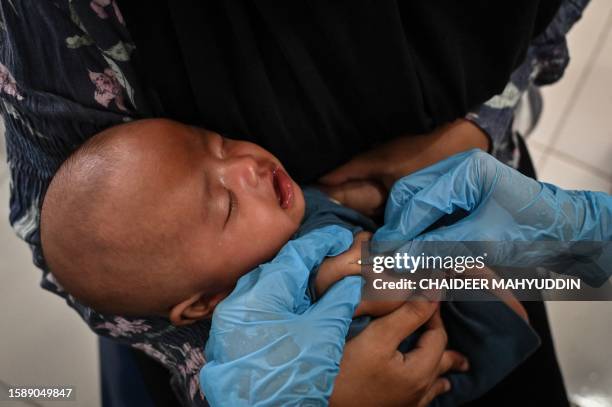 Child receives a Bacillus Calmette-Guerin vaccine to prevent tuberculosis as part of a monthly medical check-up programme for children at an...