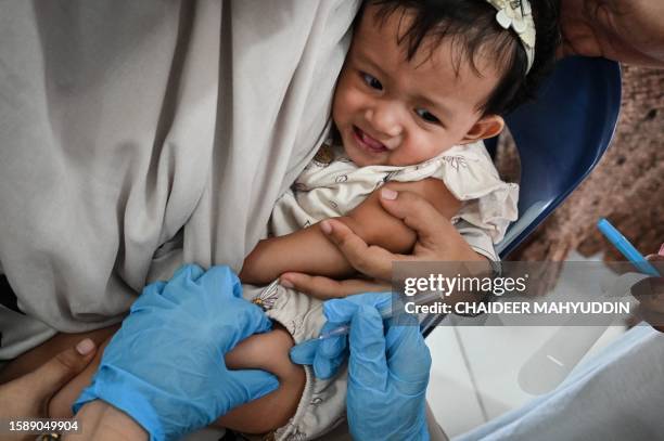 Child receives a Bacillus Calmette-Guerin vaccine to prevent tuberculosis as part of a monthly medical check-up programme for children at an...
