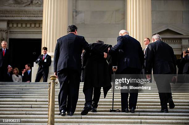 Vice President Joseph "Joe" Biden, second right, and Senator Joe Manchin, a Democrat from West Virginia, left, assist Senator Mark Kirk, a Republican...