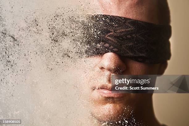 headshot of a blindfolded man disintegrating. - desintegración fotografías e imágenes de stock