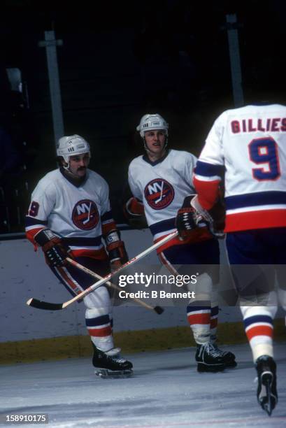 Bryan Trottier and Mike Bossy of the New York Islanders celebrate as Clark Gillies joins in during an NHL game in January, 1979 at the Nassau...