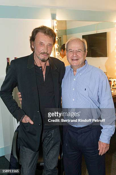 French rocker Johnny Hallyday poses with Marc Ladreit de Lacharierre in French impersonator Laurent Gerra's dressing room following Gerra's one man...