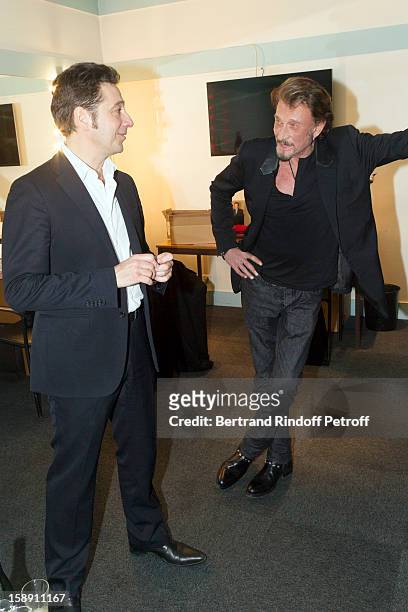 French impersonator Laurent Gerra talks with French rocker Johnny Hallyday in Gerra's dressing room following his one man show at Olympia hall on...