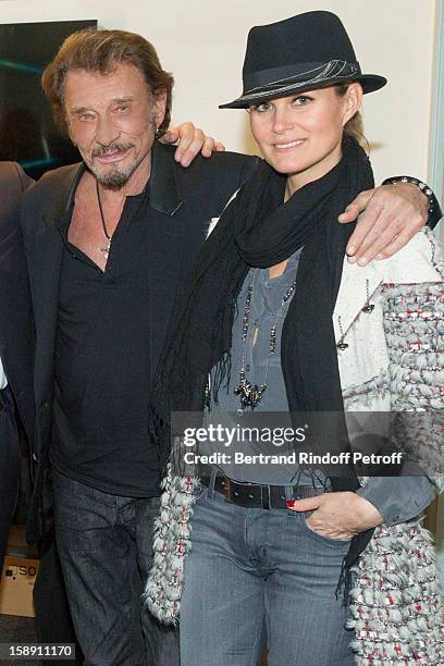 French rocker Johnny Hallyday and his wife Laeticia pose in French impersonator Laurent Gerra's dressing room following his one man show at Olympia...