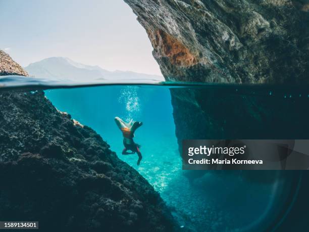 man swims underwater in the sea. - depth of field togetherness looking at the camera stockfoto's en -beelden