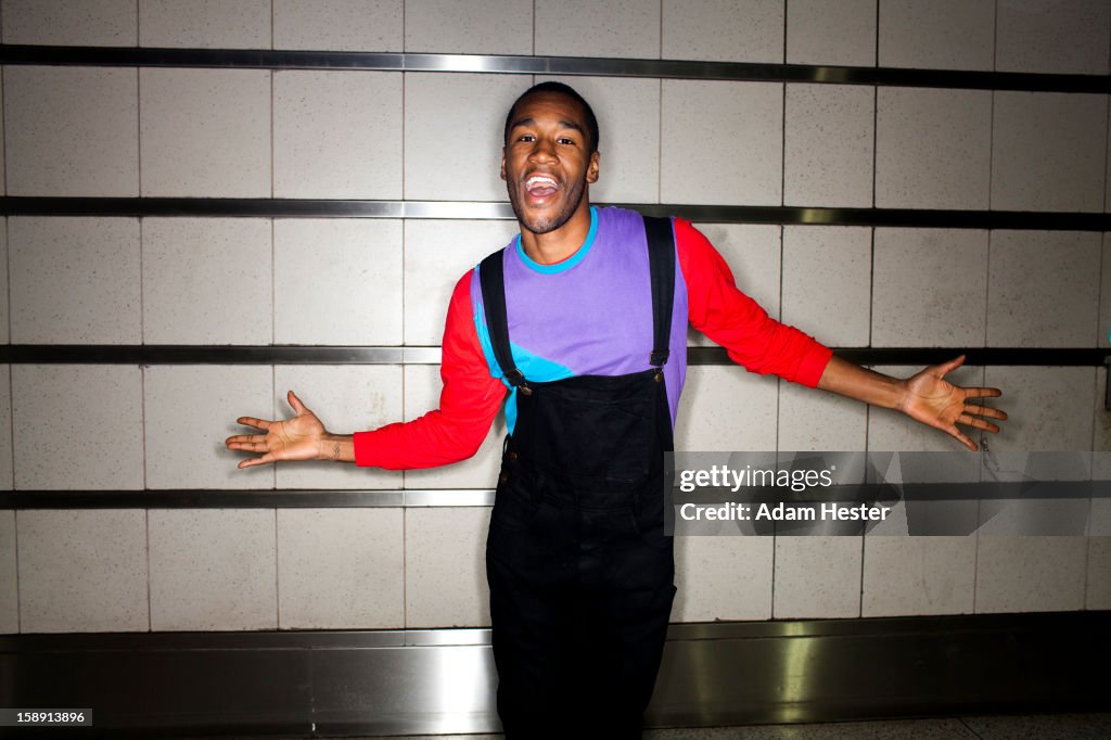 A young man dancing and smiling inside.