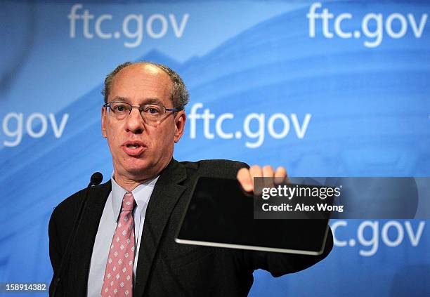 Federal Trade Commission Chairman Jon Leibowitz holds up an iPad as he speaks during a news conference regarding the agency's 21-month-long...