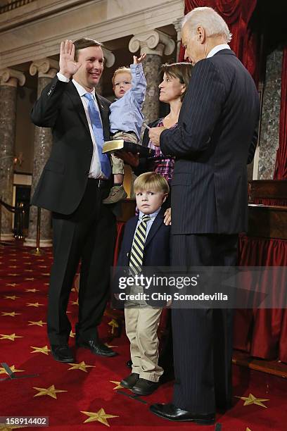 Rider Murphy raises his hand just like his father, U.S. Sen. Chris Murphy as he participates in a reenacted swearing-in with his wife Catherine...