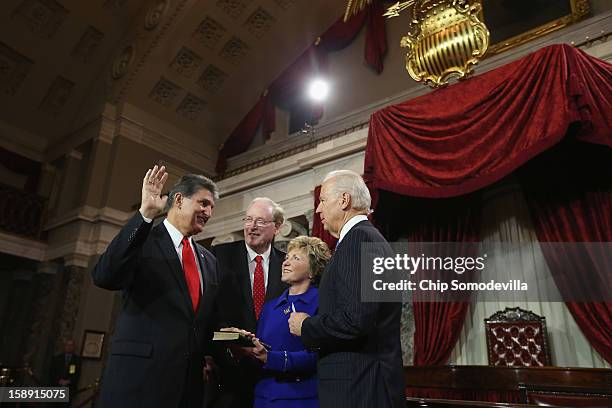 Sen. Joe Manchin participates in a reenacted swearing-in with his wife Gayle Conelly Manchin, U.S. Sen. Jay Rockefeller and U.S. Vice President Joe...