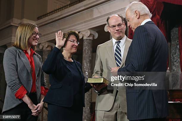 Sen. Amy Klobuchar 2nd L) participates in a reenacted swearing-in with her husband John Bessler, daughter Abigail Bessler and U.S. Vice President Joe...