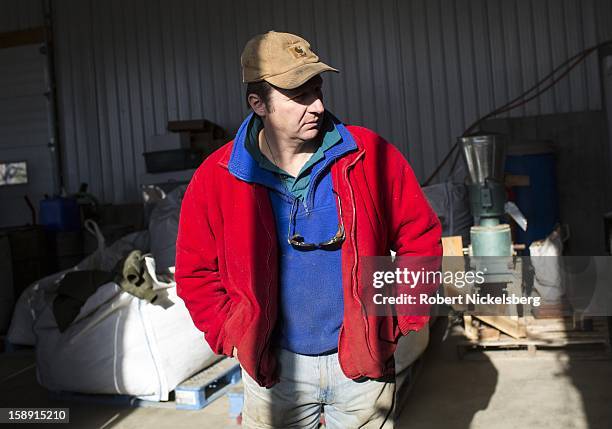 John Williamson monitors a seed crushing machine making flaxseed oil December 14, 2012 on his 200-acre organic farm in North Bennington, Vermont....