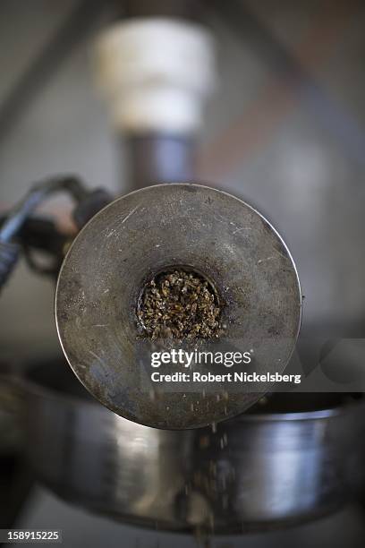 John Williamson adjusts a seed crushing machine making flaxseed oil December 14, 2012 on his 200-acre organic farm in North Bennington, Vermont....