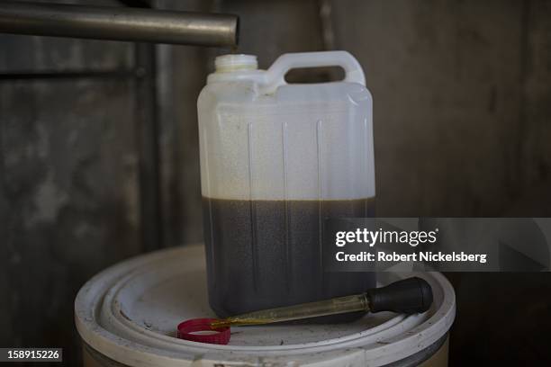 Container of freshly crushed flaxseed oil sits on a barrell December 14, 2012 at John Williamson's 200-acre organic farm in North Bennington,...